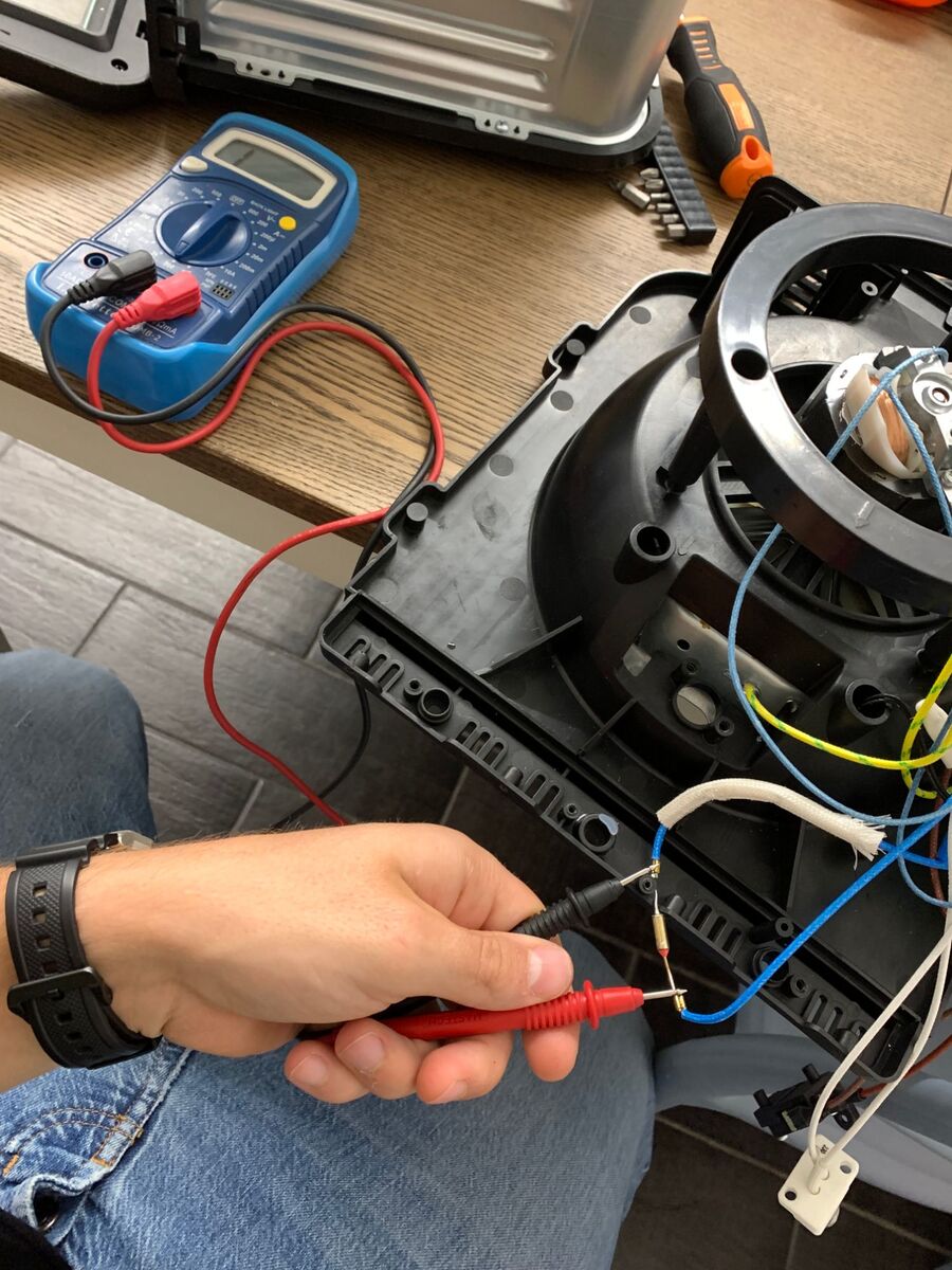 Testing the thermal fuse with the multimeter probes on both ends.