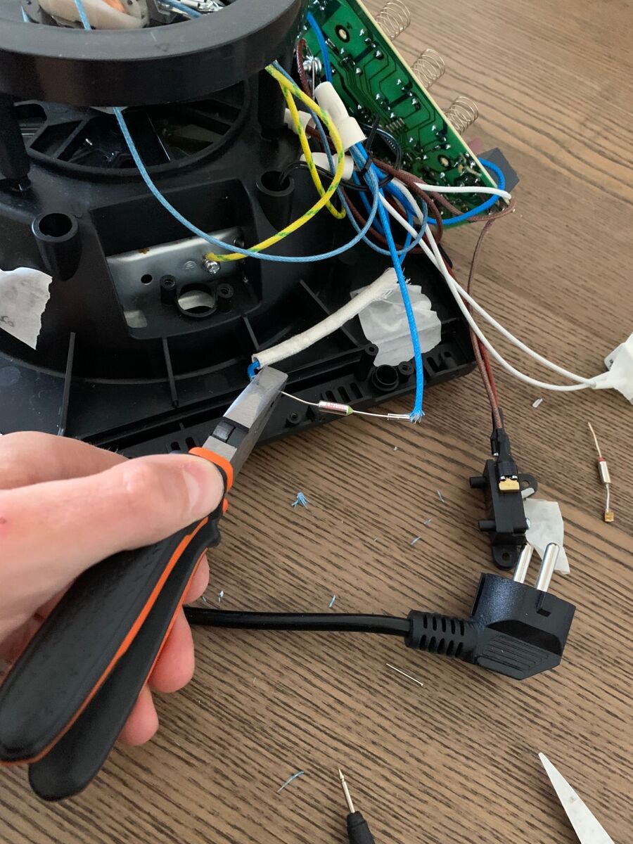 Crimping the new thermal fuse onto the blue wire with pliers.