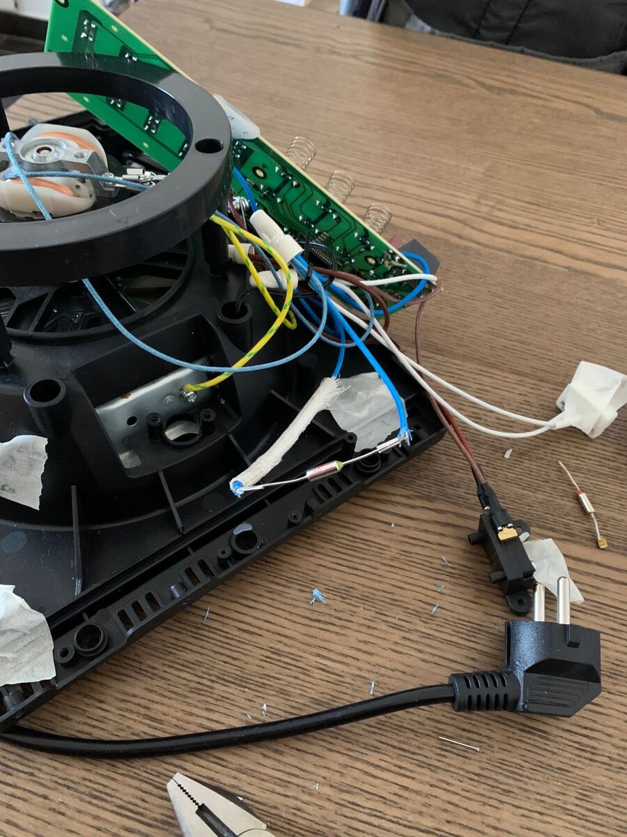 The new thermal fuse installed in the circuit, with the old one lying on the table.